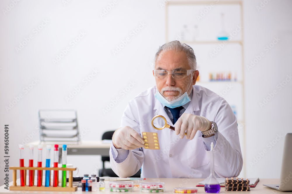 Old male chemist in drug synthesis concept Old male chemist in drug synthesis concept