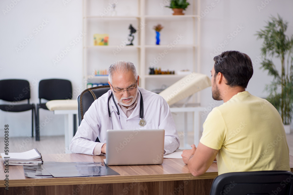 Young male patient visiting old male doctor Young male patient visiting old male doctor