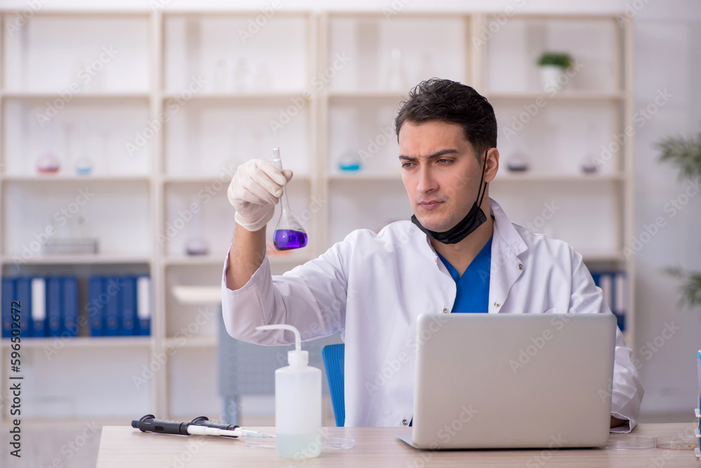 Young male chemist working at the lab