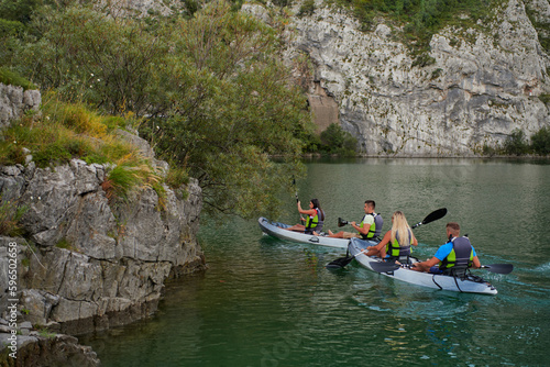 A group of friends enjoying having fun and kayaking while exploring the calm river, surrounding forest and large natural river canyons