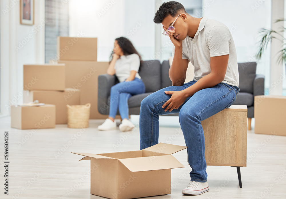 Do I have to do everything. Shot of a young man looking worried while unpacking boxes in his new house. Do I have to do everything. Shot of a young man looking worried while unpacking boxes in his new house.