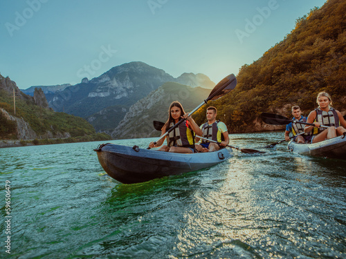 A group of friends enjoying fun and kayaking exploring the calm river  surrounding forest and large natural river canyons during an idyllic sunset.