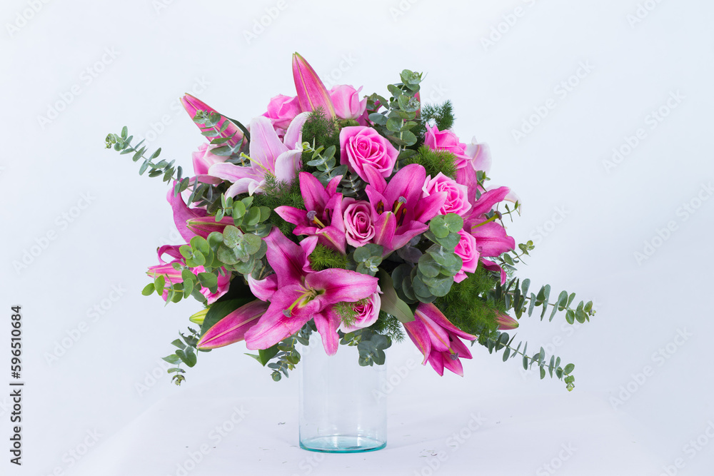 Many kinds of flowers placed in a brightly colored vase in a white setting Many kinds of flowers placed in a brightly colored vase in a white setting