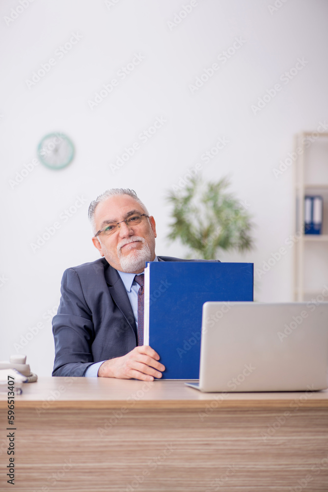 Old male employee working in the office Old male employee working in the office