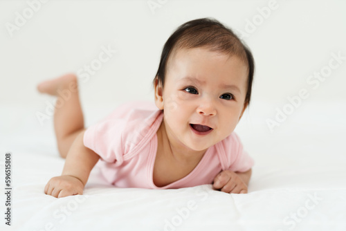 Obraz na plátně infant baby girl lying prone on bed