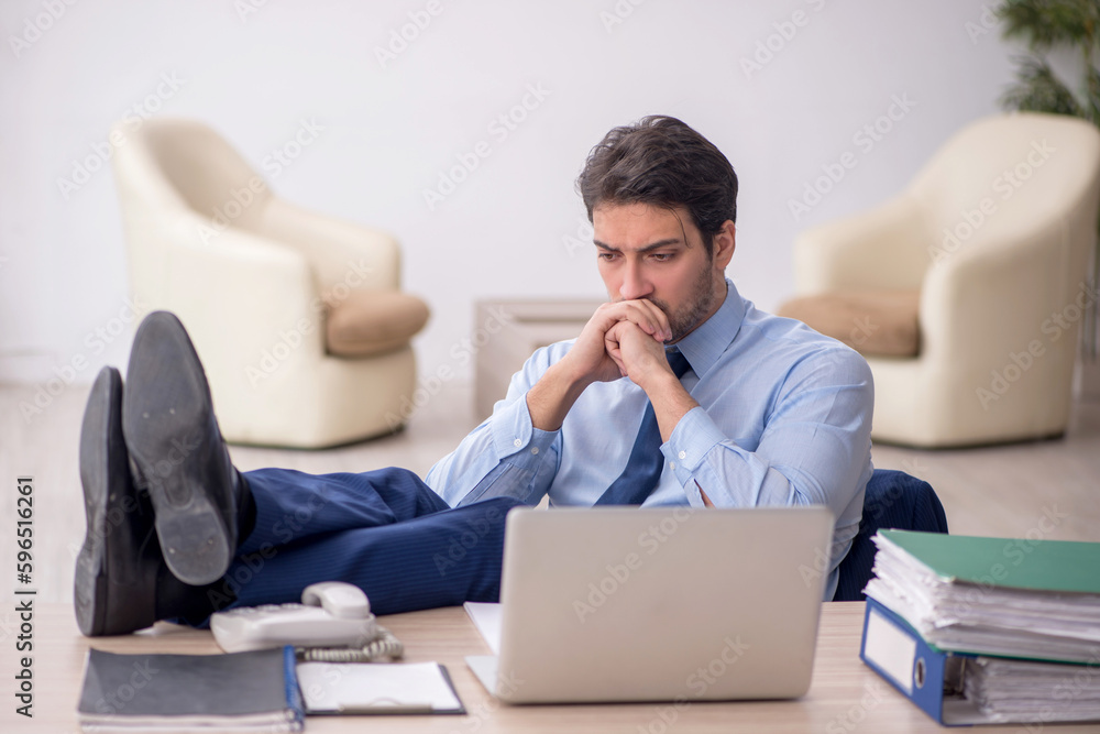 Young male employee working in the office Young male employee working in the office