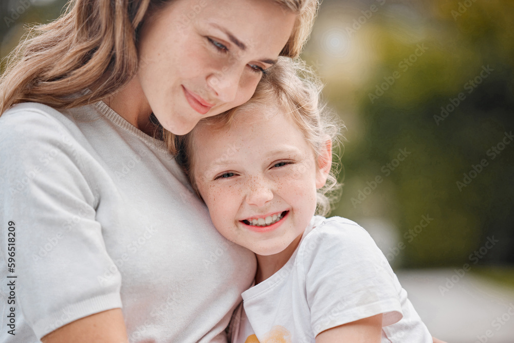Closeup of loving caucasian mother giving her adorable daughter a hug while sitting outside on a sunny day. Young mom bonding outdoors with little girl Closeup of loving caucasian mother giving her adorable daughter a hug while sitting outside on a sunny day. Young mom bonding outdoors with little girl