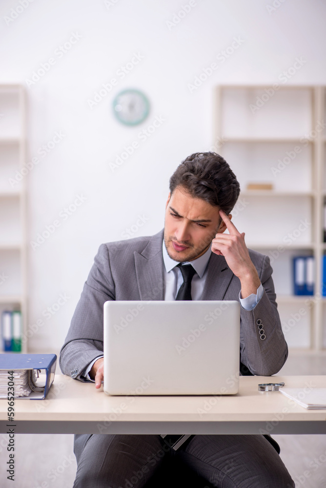 Young male employee working in the office Young male employee working in the office