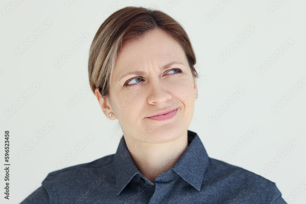 Suspicious woman squints looking to side and thinking Suspicious woman squints looking to side and thinking