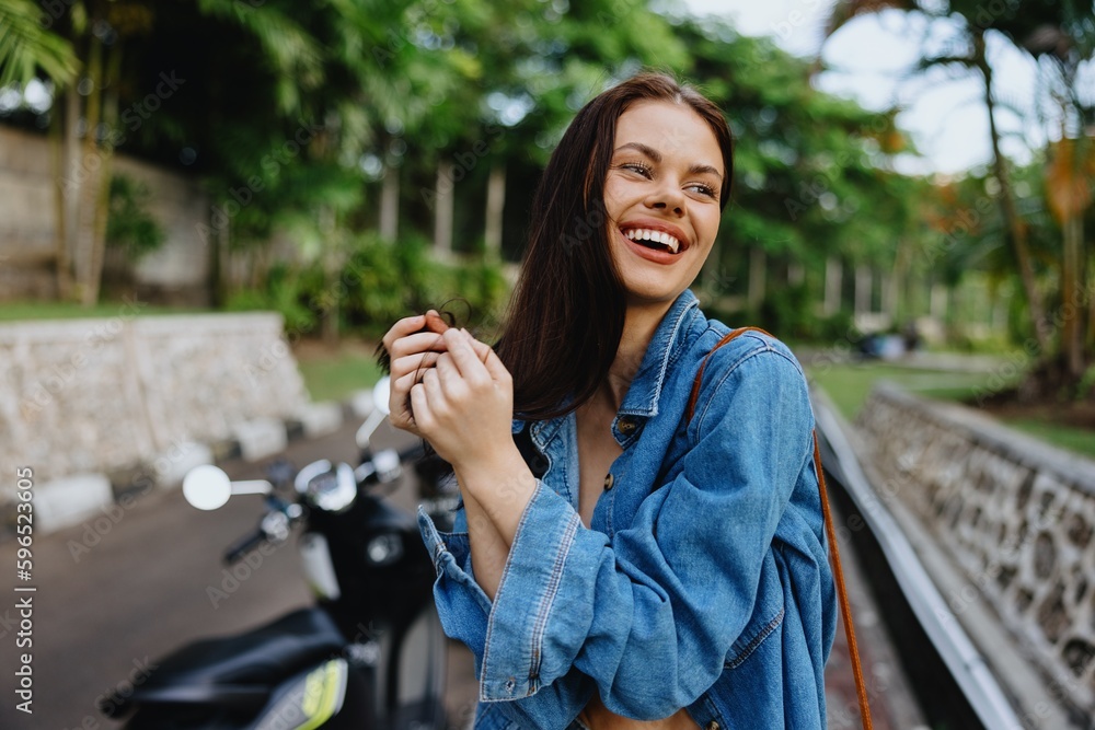 Portrait of a woman brunette smile with teeth walking outside against a backdrop of palm trees in the tropics, summer vacations and outdoor recreation, the carefree lifestyle of a freelance student. Portrait of a woman brunette smile with teeth walking outside against a backdrop of palm trees in the tropics, summer vacations and outdoor recreation, the carefree lifestyle of a freelance student.