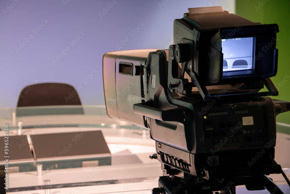 TV studio with professional camera aiming at empty seat, focus on camera. TV studio with professional camera aiming at empty seat, focus on camera.