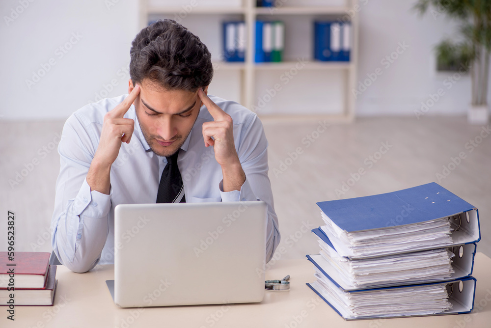 Young male employee working in the office Young male employee working in the office