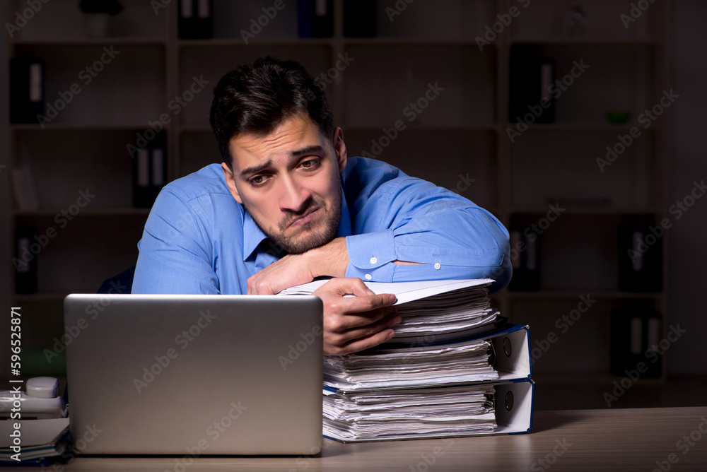 Young male employee working late in the office Young male employee working late in the office