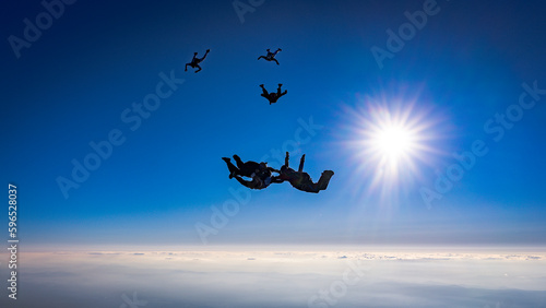 Skydiver group builds formation in the blue sky silhouette