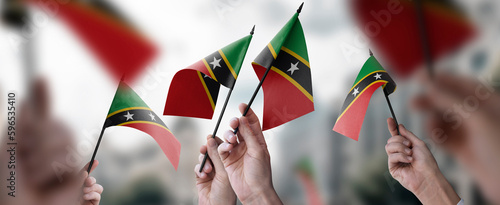 Fototapeta Naklejka Na Ścianę i Meble -  A group of people holding small flags of the Saint Kitts and Nevis in their hands