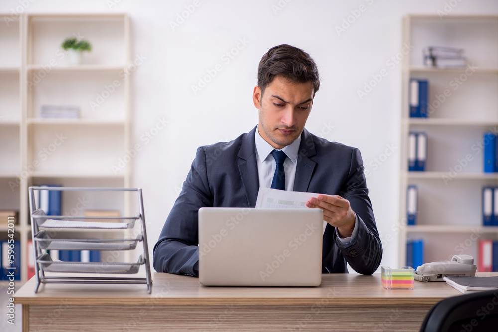 Young male employee working in the office Young male employee working in the office