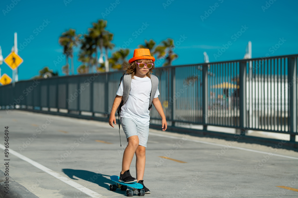 Boy on skateboard skating. Kid with skateboard. Child hold skate board. Healthy sport and activity for school kids in summer. Sports fun.