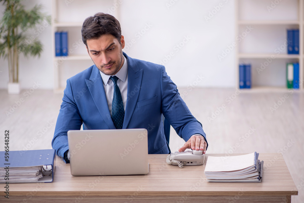 Young male employee working in the office Young male employee working in the office