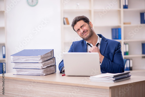 Young male employee and too much work in the office