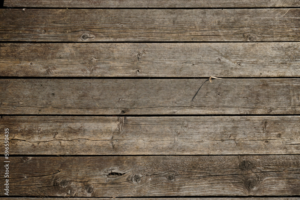 The texture of natural materials. Boardwalk pier on the river bank in the rain and sun	