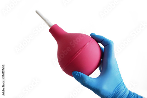 Canvastavla Doctor in blue medical gloves holding red enema isolated on white background, co