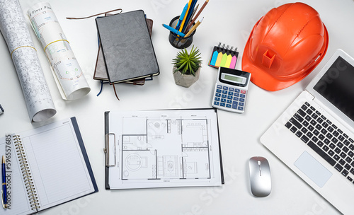 home plan and tools laptop hardhat helmet on white office desk