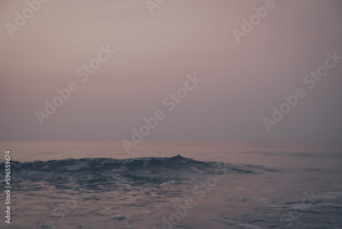 the wave in the beach before sunrise and the vanilla clearly sky, the landscape photo of the beautiful lonely beach on the dawn with no people and cloud.