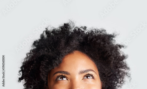 Woman, eyes looking up and cropped in studio with thinking, ideas and hope by gray background. Young female model, african girl and think for mindset with afro, vision and daydream by backdrop
