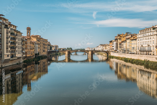 Gorgeous view of an old stone bridge across a river in Italy on a sunny warm summer evening on a blue sky. The concept of historical important infrastructural structures in Europe. Copyspace © Pavel