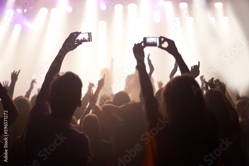 Music, festival and hands of audience with phone for pictures, celebration and enjoying night, concert or event. Party, people and performance with excited fans showing support, passion and recording