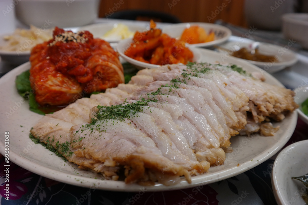 Korean traditional food with thinly sliced boiled pork and freshly made cabbage kimchi Korean traditional food with thinly sliced boiled pork and freshly made cabbage kimchi