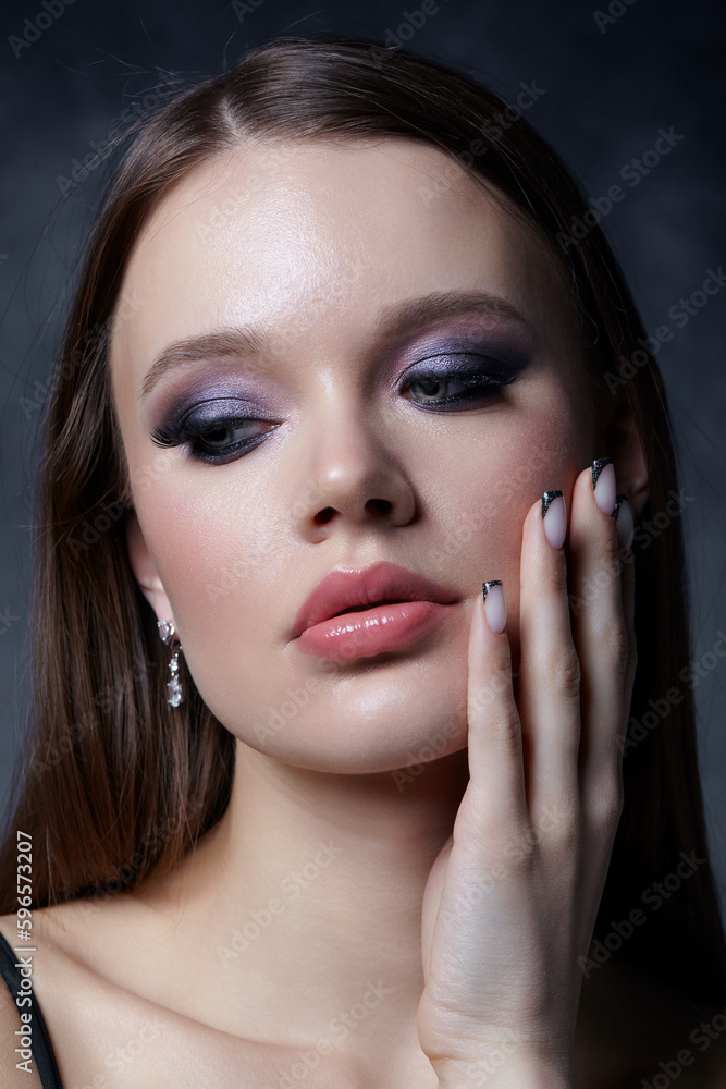 Obraz premium Portrait of female face. Hand with black french manicure nailsnear face