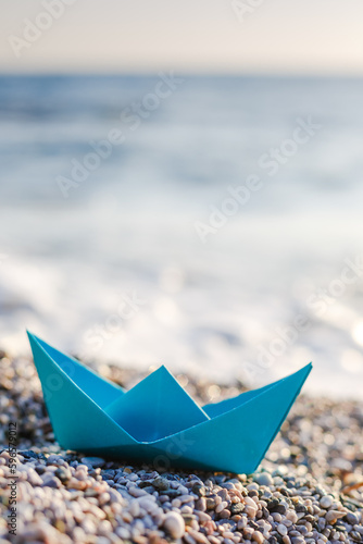 Origami paper boat on the beach
