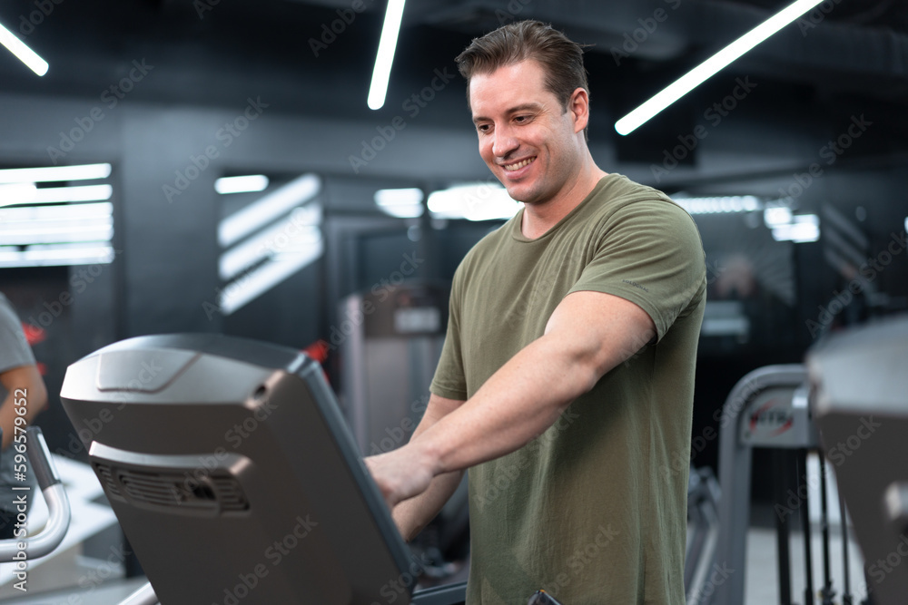 Caucasian man with exercise machine at fitness gym	