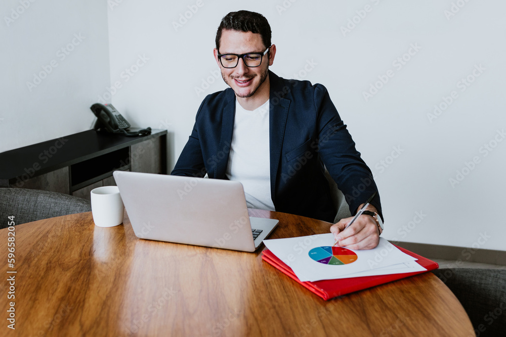 young latin businessman working and using laptop or computer in smart casual clothes at office in Mexico, hispanic people young latin businessman working and using laptop or computer in smart casual clothes at office in Mexico, hispanic people