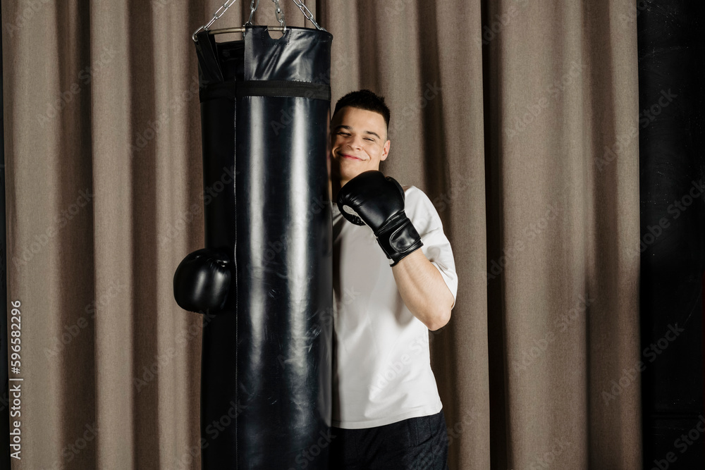 Boxer training with a punching bag in a cozy beige studio.