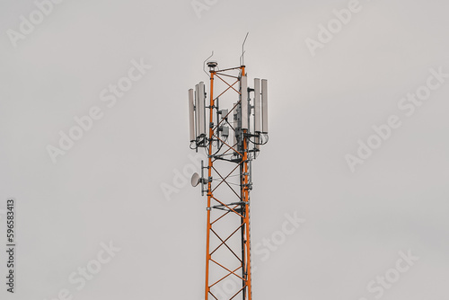 A cell phone tower with a dark sky behind it.
