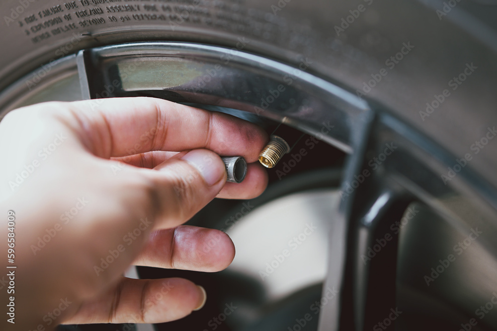 Car mechanic checking tire pressure gauge
