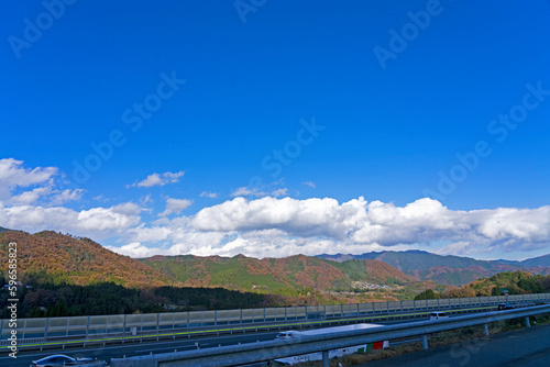 高速道路越しの青空と低い雲と山
