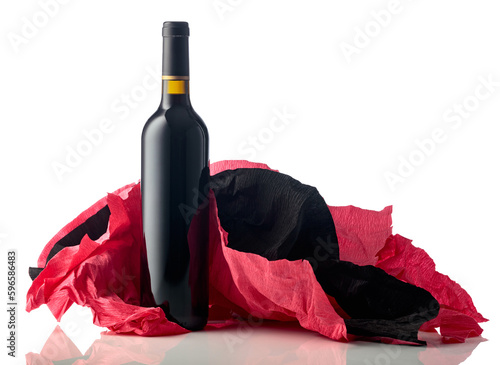 Bottle of red wine with crumpled crepe paper isolated on a white background.