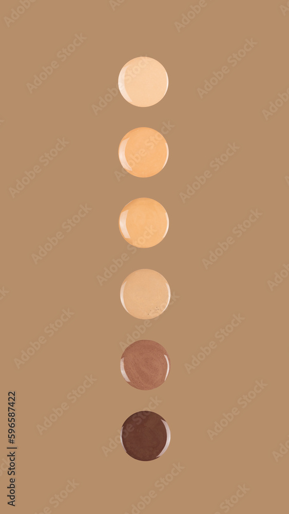 Diverse skin tone makeup foundation drops on brown background.