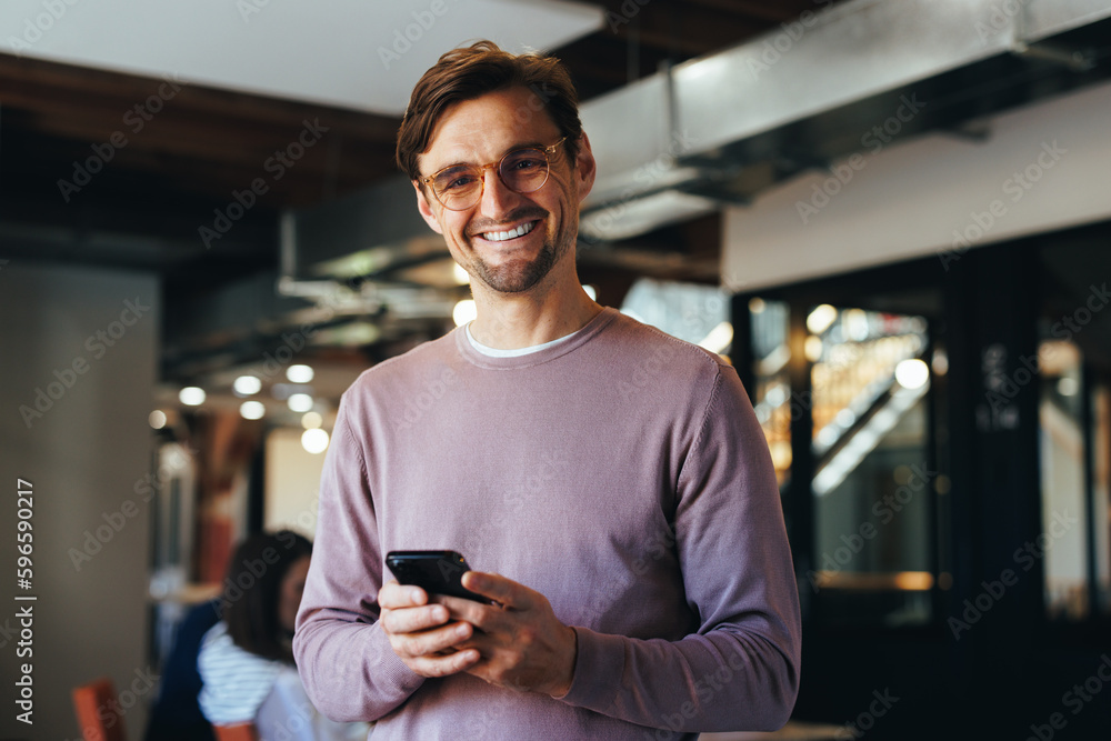 Portrait of a business man holding a cellphone in an office Portrait of a business man holding a cellphone in an office