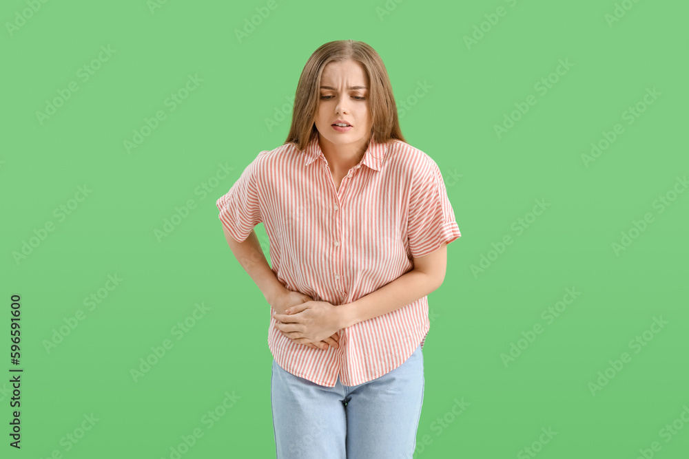 Young woman with appendicitis on green background Young woman with appendicitis on green background