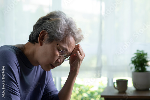 Photography Portrait of sad and lonely Asian senior woman in living room