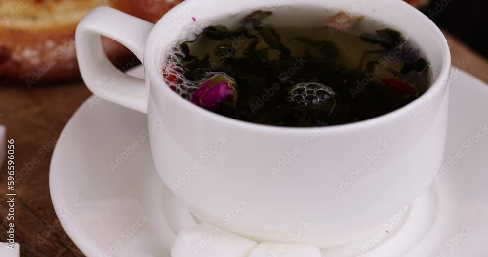brewing green tea with hot boiled water in a white mug, a mug made of ...