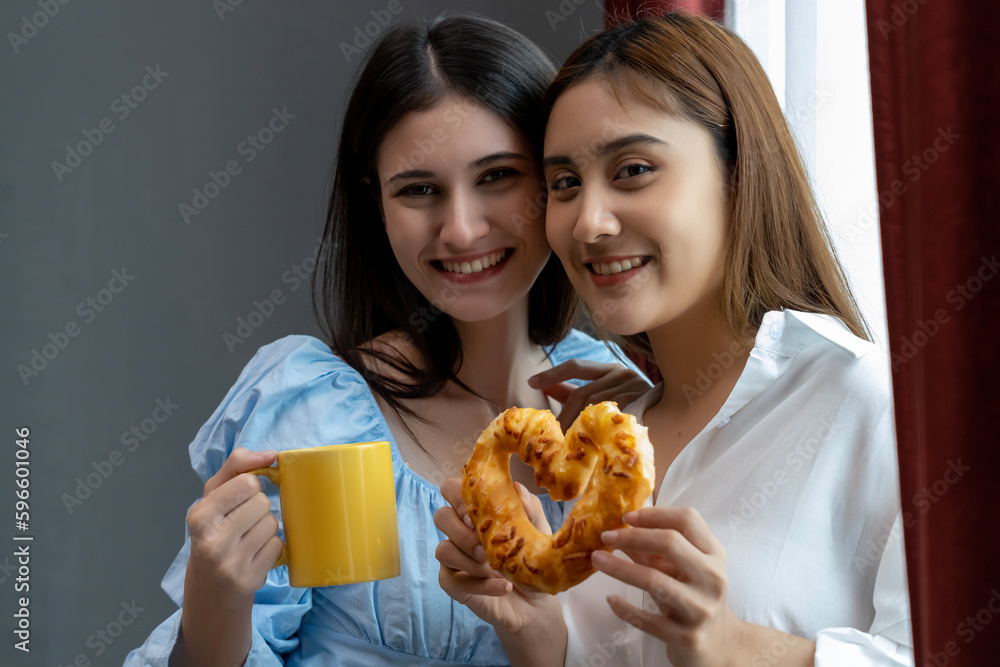 Happy moment of Two pretty women drink coffee and talk together in kitchen Happy moment of Two pretty women drink coffee and talk together in kitchen