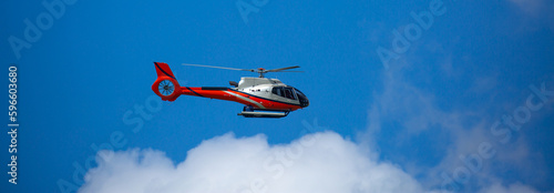 Rescue helicopter flies in the sky among the clouds. Red-white Helicopter. photo