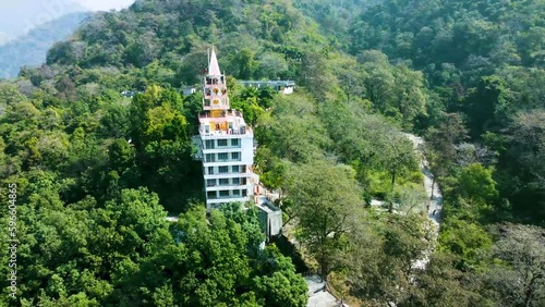 isolate multistory hindu temple in the middle of the forests from different angle aerial shot video is taken at bhutnath temple rishikesh uttrakhand india on Mar 15 2022. photo