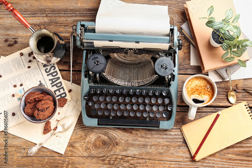 Cup of coffee with typewriter, notebook, cookies, cezve and newspaper on wooden background