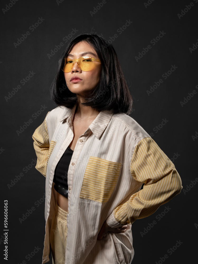 A portrait of a casual fashion-style Asian (Chinese Indonesian) Girl posing dan dancing with a Hip hop style. Isolated on a black background A portrait of a casual fashion-style Asian (Chinese Indonesian) Girl posing dan dancing with a Hip hop style. Isolated on a black background